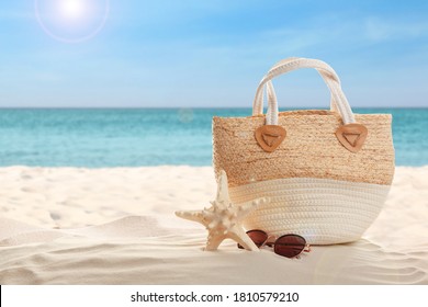 Bag and stylish glasses on sand near ocean, space for text. Beach accessories - Powered by Shutterstock