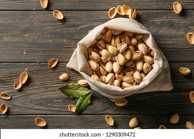 Bag With Tasty Pistachio Nuts On Wooden Background