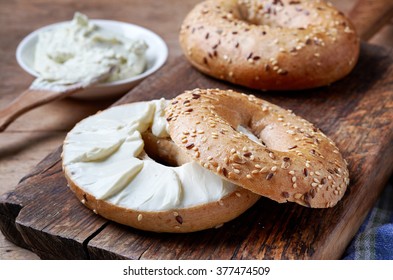 Bagel With Cream Cheese On Wooden Table