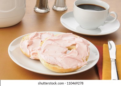 A Bagel With Strawberry Cream Cheese And Coffee