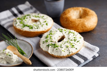 Bagels with fresh cheese and herbs on a breakfast table , with fresh orange juice and coffee on the side. - Powered by Shutterstock