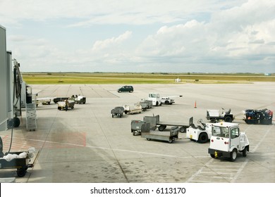 Baggage Cars At An Airport Terminal.