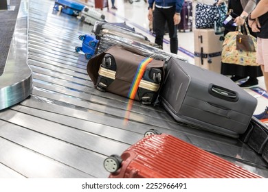 Baggage luggage at airport arrival carousel with passengers awiating to claim theirs - Shutterstock ID 2252966491