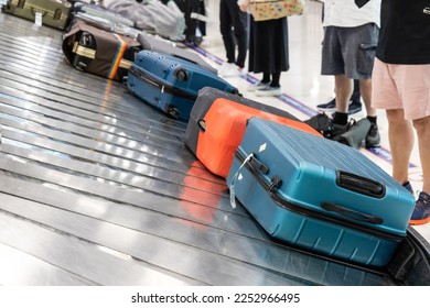 Baggage luggage at airport arrival carousel with passengers awiating to claim theirs - Shutterstock ID 2252966495