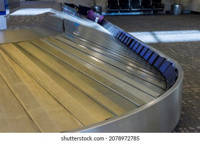 Baggage Pickup Carousel With On A Luggage Belt At The Airport Terminal