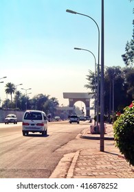 BAGHDAD, IRAQ - CIRCA 2007: Main Road Running In Front Of The Old US Embassy Compound, Towards A Sadaam-era Brick Arch Gate