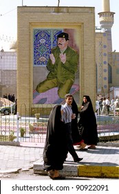 BAGHDAD, IRAQ - MARCH 11: Iraqis Pass By A Mosaic Of Iraqi President Saddam Hussein Praying. Saddam Has In The Past Few Months Commissioned Hundreds Of New Monuments To Himself On March 11, 1999 In Baghdad, Iraq.