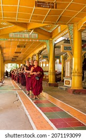 BAGO, MYANMAR - November 26, 2015: Monks waiting in a row to go to the dining room in Kha Khat Waing Kyaung Monastery, Bago, Myanmar