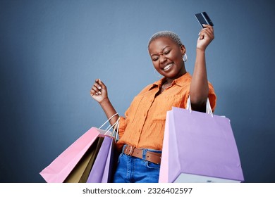 Bags, excited and black woman with a credit card, shopping and boutique items on a grey studio background. Female person, shopper or model with celebration, payment and smile with sales and luxury - Powered by Shutterstock