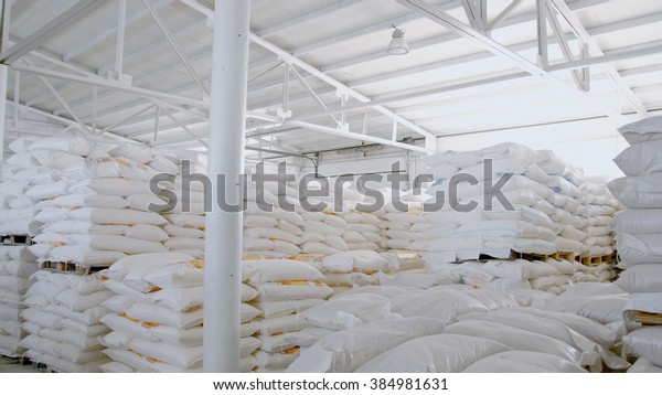 Bags with flour in warehouse of flour factory.\
Flour stock. Mill\
warehouse.