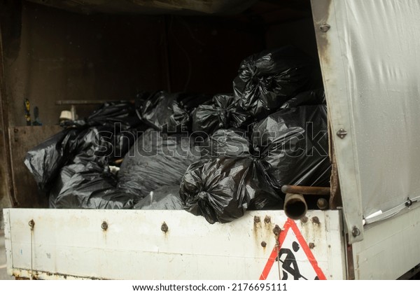Bags of garbage in car. Black packages in\
back of car. Transportation of unknown\
cargo.