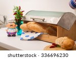 Baguette, lying in a breadbox, made of wood with metal lid