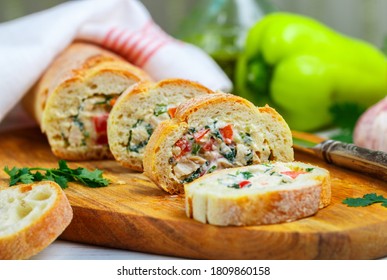 Baguette stuffed with a salad of baked chicken, cheese and fresh vegetables-bell pepper, tomato, garlic, parsley. Delicious homemade appetizer for gourmets. Selective focus