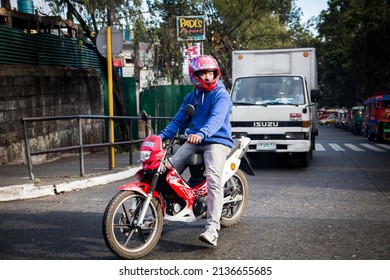 BAGUIO CITY, PHILIPPINES - JANUARY 2019: A Motorcyclist Waits At Intersection In Baguio City.  Motorcycles Are One Of Many Ways To Get Around The Crowded Metropolitan Center Of Town.