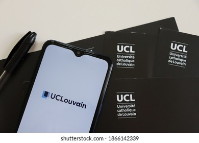 Bahia, Brazil - December 2, 2020. UCLouvain Logo On Smartphone Screen On Top Of The University Folders. UCLouvain Is The Catholic University Of Louvain.