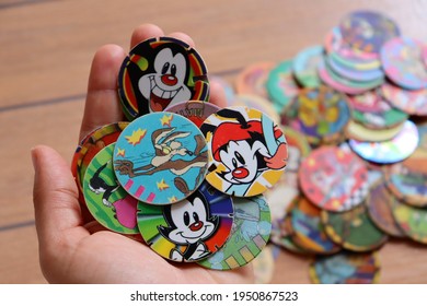 Bahia, Brazil - March 23, 2021:  Girl's Hand Holding Collection Of Tazos. Looney Tunes Tazos. 