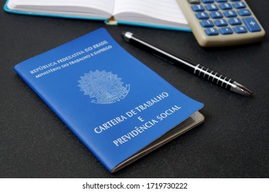 Bahia, Brazil. May 1, 2020. Translation: Work Record Booklet And Social Welfare / Brazilian Work Card (carteira De Trabalho), Pen, Calculator And Notepad. Brazilian Pension System. Retirement Concept.