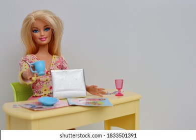 Bahia, Brazil. October 14, 2020. Barbie Doll Holding A Cup Of Coffee, And Working From Home. Laptop And Magazines On Home Office.