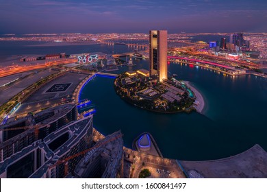 Bahrain Bay, Manama, Bahrain - December 27, 2019 : Arial Cityscape Night View Of Manama City, Diplomatic Area, Four Seasons Hotel, Arcapita, Al Baraka, Muharraq Bridge In Blue Hour With City Lights