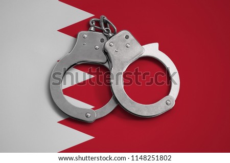 Bahrain flag  and police handcuffs. The concept of observance of the law in the country and protection from crime