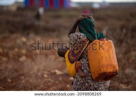 Baidoa, Somalia - May 15, 2019: Women carrying water on their heads in Africa