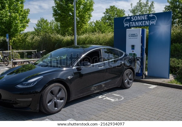 Baierbrunn,
Germany - May 16, 2022: A static shot of a solid black Tesla Model
3 dual motor charging at the Aldi supermarket DC charging station
in a sunny spring day. Selective
focus.