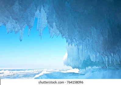 Baikal Lake. Thick blue ice and icicles on the coastal rocks of Olkhon Island in winter. Natural cold background