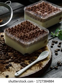 Baileys Tiramisu With Ball Tops Are Presented In Glass Boxes. Photographed In A Dark And Vintage Concept With Coffee Bean Decoration.