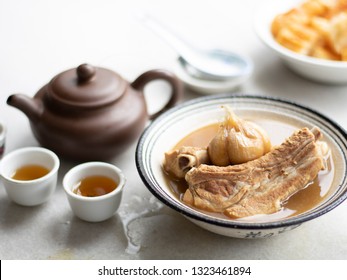 Bak kut teh or Bakut is a pork rib dish cooked in broth, served in Malaysia and Singapore. Bak kut teh and tea pot. Bak kut teh with dough fritters.