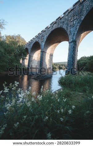 Bake Thin Viaduct spanning Bakethin Reservoir in Northumberland, captured with clear views of the stone arches and calm reflective water