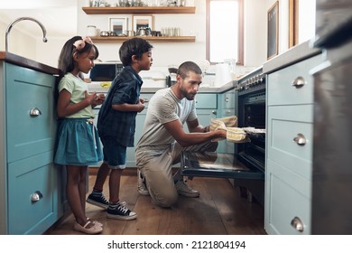 Bake The World A Better Place. Shot Of A Young Man Baking At Home With His Two Young Kids.