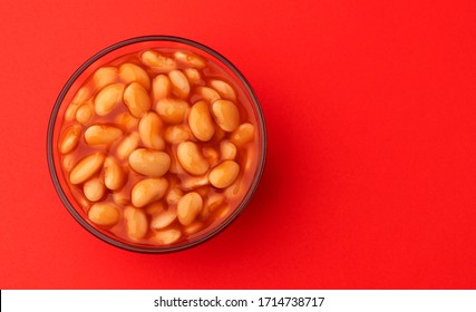 Baked Beans In Tomato Sauce Isolated On Red Background With Copy Space, Top View