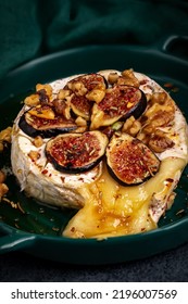  Baked Brie With Nuts And Figs In A Green Bowl. Close Up.