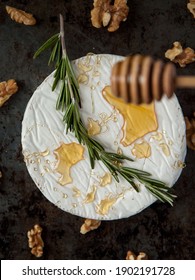 Baked Brie with Rosemary, Honey, and Candied Walnuts on a dark background. Top view