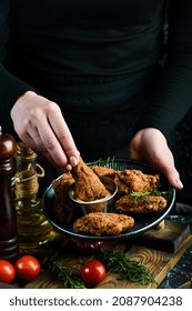 Baked Buffalo Chicken Wings On A Plate In The Hands Of A Chef On A Black Background.