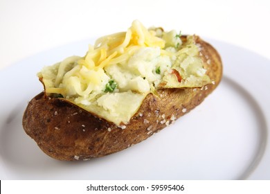 A Baked Burbank Russet Or Idaho Potato, Filled With Parsley Creamed Potato And Topped With Grated Cheese, On A White Plate Providing Space For Text