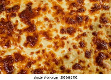 Baked cheese crust texture close-up. The surface of the finished lasagna. Cooking technique of Italian cuisine. - Powered by Shutterstock