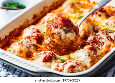 Baked Cheesy Meatballs Casserole With Tomato Sauce In The Oven Dish.