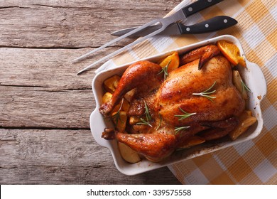 Baked Chicken With Apples In The Baking Dish On A Table. Horizontal Top View
