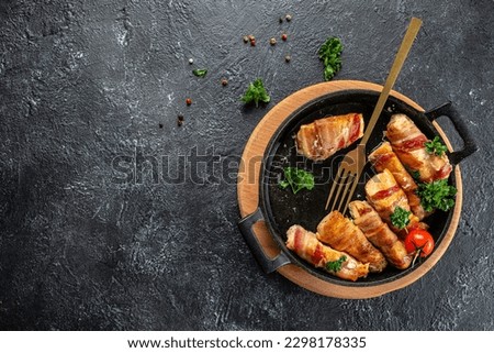 Baked chicken breast wrapped in bacon on a cast-iron frying pan. Concept healthy and balanced eating. place for text, top view.
