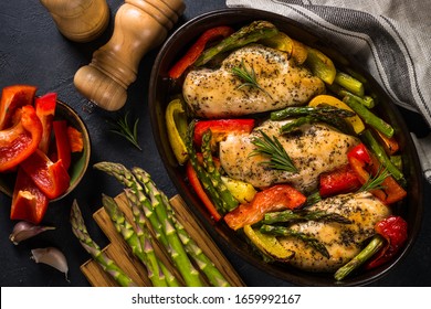 Baked chicken fillet with vegetables. Healthy food, keto diet, one pot dish. Top view at dark table. - Powered by Shutterstock