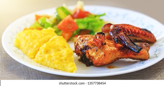 Baked Chicken Legs, Polenta Or Mamaliga And Salad In Fancy Plate. Traditional Food And Culinary Culture Specific For Balkan Countries Like Romania, Moldova And Ukraine. Concept For Healthy Dinner. 