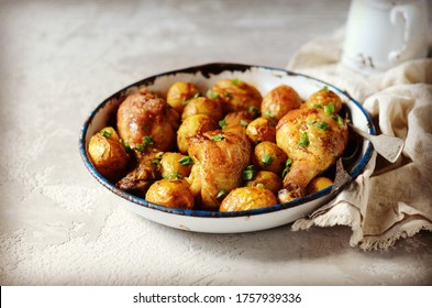 Baked chicken legs with young potatoes in a baking dish on a gray background - Powered by Shutterstock