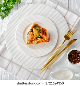 Baked Chicken Tamale Pie Or Chicken Casserole With A Cornmeal Mix Crust, Cheddar Cheese, Black Beans Served On A Plate With Sour Cream On A White Wooden Background, View From Above, Close-up