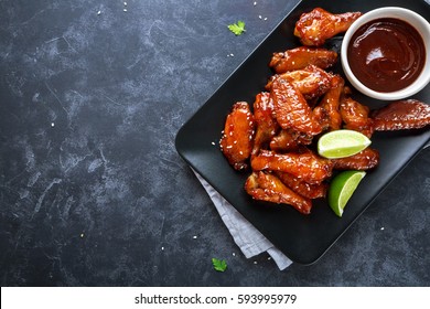 Baked chicken wings with sesame and sauce. Food background with copy space. Top view