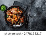 Baked chicken wings with sweet chili sauce in a plate. Black background. Top view. Copy space.