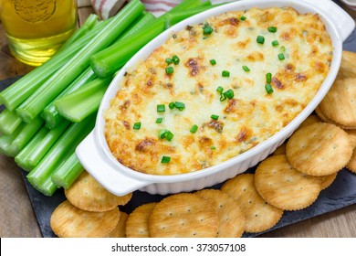 Baked crab dip, served with celery sticks and crackers, top view