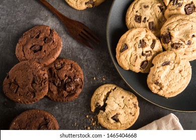 Baked Creamy Dark chocolate chip cookies , Cookie crumble cracks and Brownie chocolate chip cookie on the black dish plated on dark texture background Image using for commercial or menu layout design 