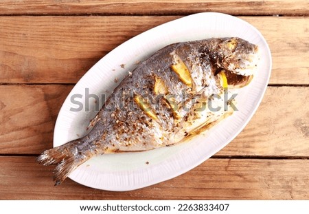 Baked Dorada fish with lemon and herbs, gilt head bream