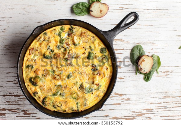 Baked egg\
frittata with spinach, cheese, broccoli, red potatoes, bacon, milk,\
and spinach far away shot from\
top